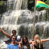 students posing in front of waterfall
